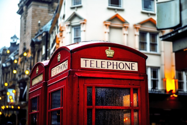 Classic British red colored pay telephone booths in London, England, UK. Horizontal composition.
