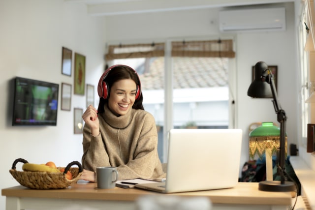 happy young woman working from home on a laptop
