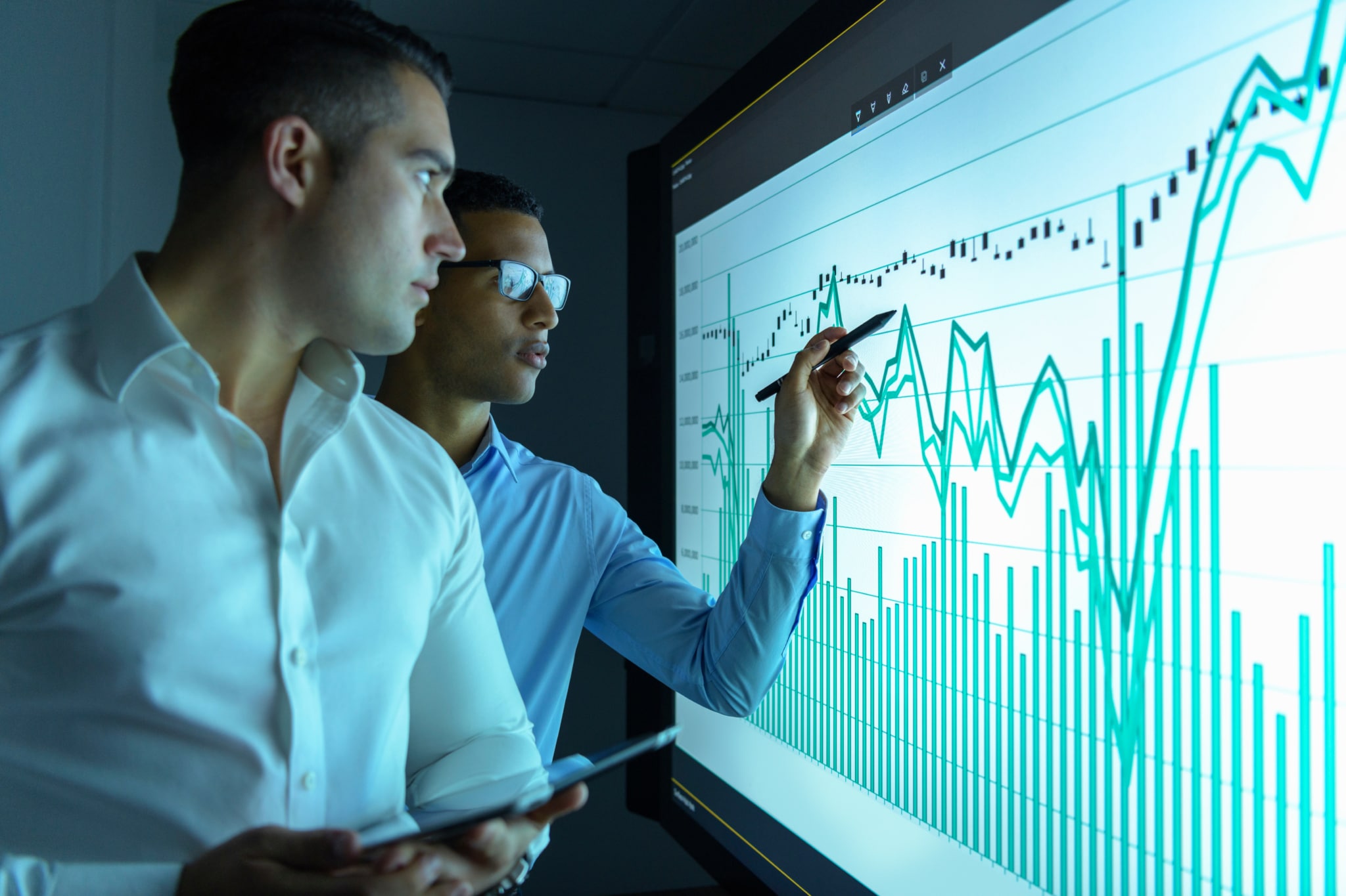 Businessmen studying graphs on an interactive screen in business meeting-418
