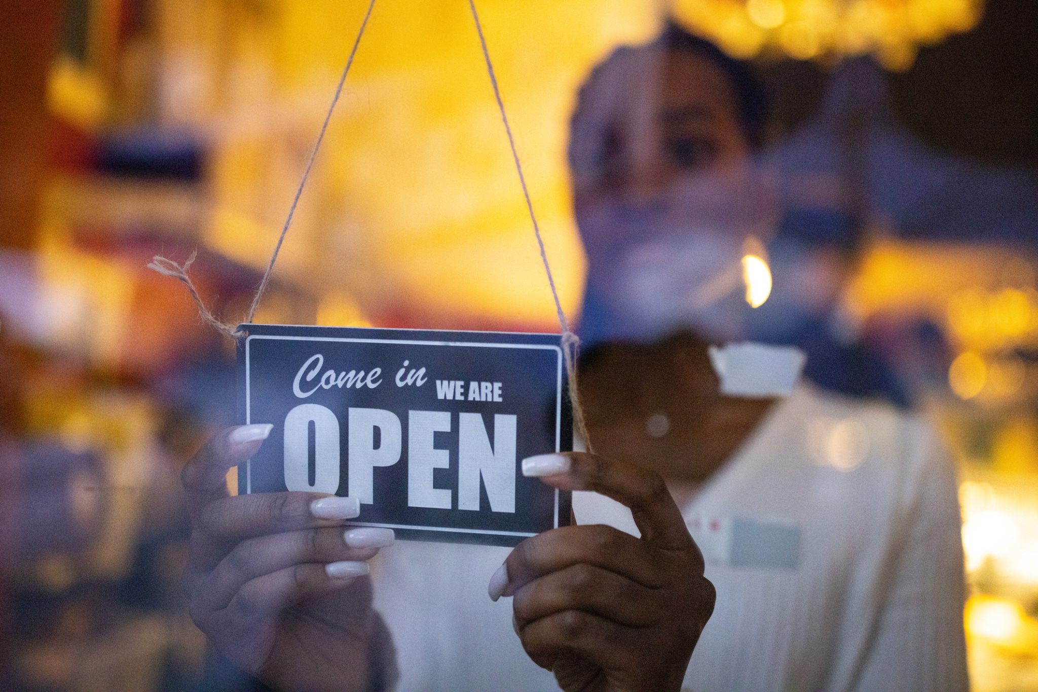 Business owner hanging an open sign